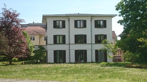 a white house with black windows on a hill at Architekten Villa in Theaternähe in Meiningen