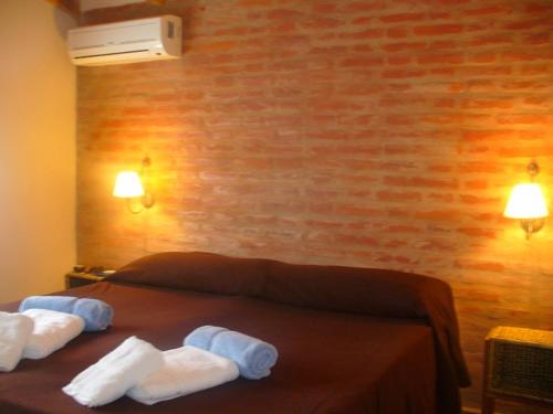 a bedroom with a bed with towels on it at Chalets Los Abedules in Villa General Belgrano