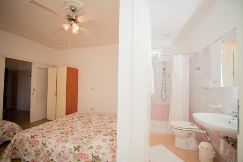 a bedroom with a bed and a bathroom with a sink at Appartamenti & Bungalows Luca Angiolin in Cavallino-Treporti