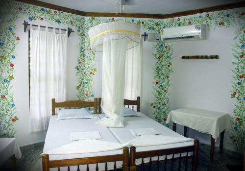 two beds in a room with floral wallpaper at Jickys Nest in Varkala