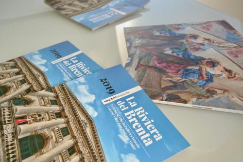 two pamphlets sitting on a table next to a book at Ahr Hotel Villa Alighieri in Stra