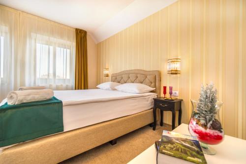 a bedroom with a bed and a christmas tree on a table at Casa Moritz in Braşov
