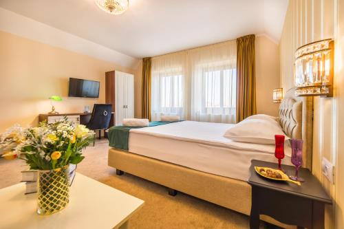 a hotel room with a bed and a table with flowers at Casa Moritz in Braşov
