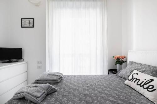 um quarto com uma cama com almofadas e uma televisão em Stupendo e accogliente apt (15 min dal Duomo) em Milão