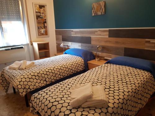 a bedroom with two beds with towels on them at Hotel La Torre in Cogoleto
