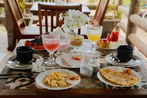 uma mesa coberta com pratos de comida e bebidas em Casa Valentini Pousada em Jericoacoara