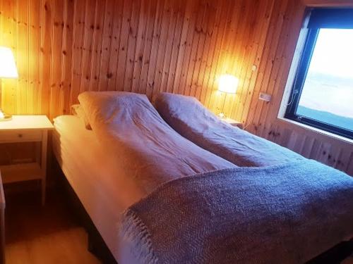 a small bedroom with a bed and a window at Hekla Cabin 3 Volcano and Glacier View in Hella