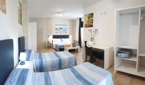 ein Hotelzimmer mit 2 Betten und einem Schreibtisch in der Unterkunft Torre Guaceto Greenblu Resort in Carovigno