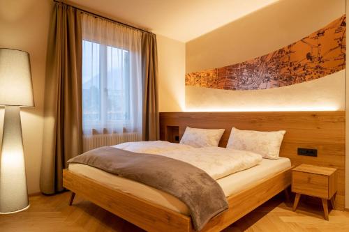 - une chambre avec un lit et une grande fenêtre dans l'établissement Ladurner Suites, à Merano