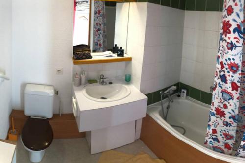 a bathroom with a sink and a toilet and a bath tub at Vue magnifique et balcon orienté sud - T2 pour 5 personnes in Les Deux Alpes