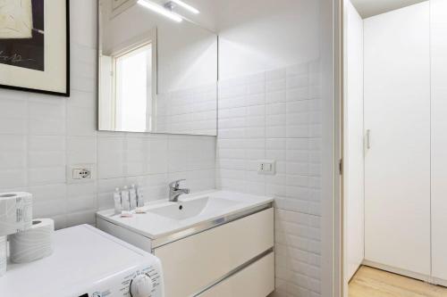 bagno bianco con lavandino e specchio di Spacious flat close to Fondazione Prada & Metro a Milano