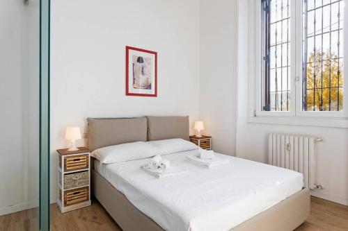 una camera da letto con un letto con due tavoli e una finestra di Spacious flat close to Fondazione Prada & Metro a Milano