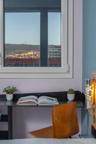 an open book on a desk with a window at Eklo Clermont Ferrand Centre Gare in Clermont-Ferrand