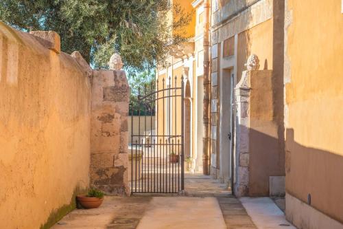 an alley with a gate between two buildings at Masseria Testaferrata in Siracusa