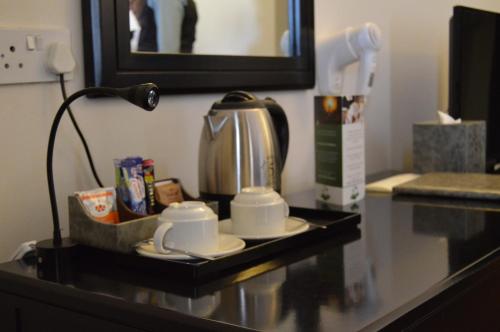 a table with a coffee pot and cups on it at Majestic Five Hotel in Palatswe