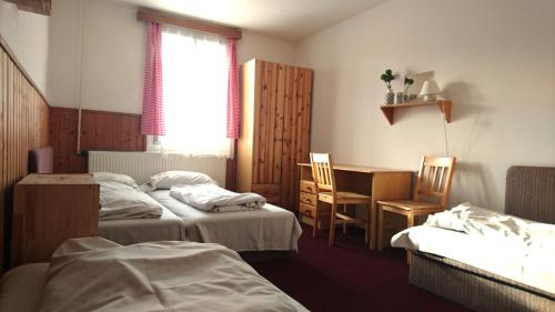 a hotel room with two beds and a table and chairs at Chata Luna in Orlické Záhoří 