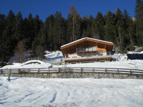 ein großes Gebäude im Schnee mit Schnee in der Unterkunft Bergappartement Talblick in Sankt Veit in Defereggen