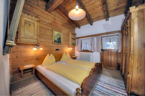 a bedroom with a bed in a wooden room at Ferienhäuser Reither Almen in Reith im Alpbachtal