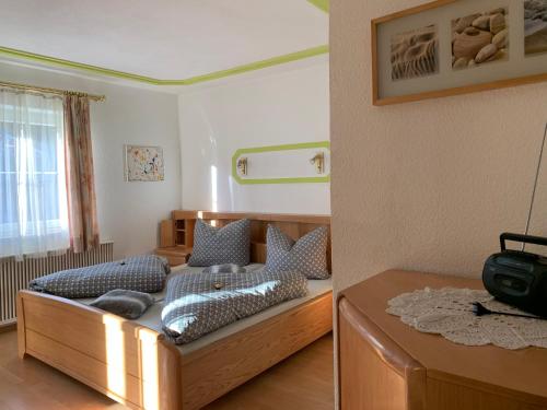 um quarto com uma cama de madeira com almofadas em Ferienwohnung Urisee em Reutte