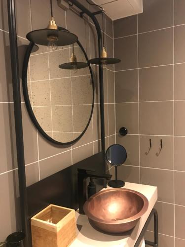 a bathroom with a copper sink and a shower at Slipens Hotell in Fiskebäckskil