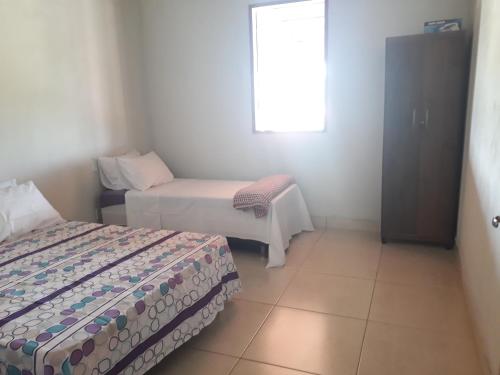 a room with two beds and a table and a window at Chácara Sossego in Capitólio