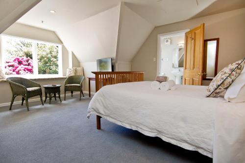 a bedroom with a large bed and a table and chairs at Orari Boutique Hotel in Christchurch