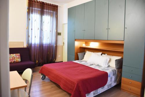 um quarto com uma cama, uma cadeira e uma mesa em B&B via Roma em Bernate Ticino