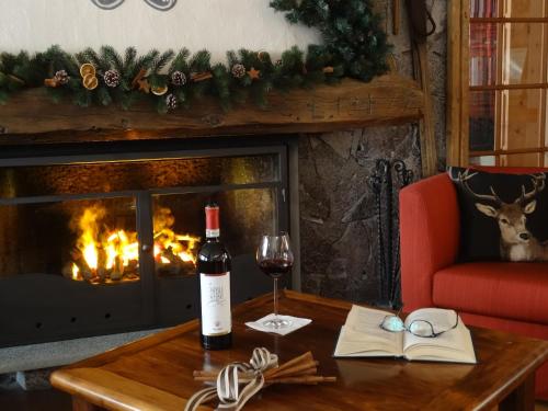 a bottle of wine on a table next to a fireplace at Hotel Larice Bianco in Bormio