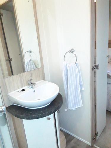 a bathroom with a sink and a mirror at Clearwater lodge Widemouth sands in Poundstock