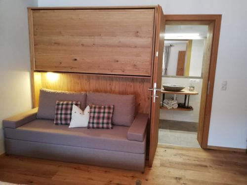 a couch with two pillows on it in a room at Bauernhof Bichlhof in Söll