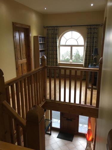 a room with a wooden staircase with a window at Rosswood House in Donegal