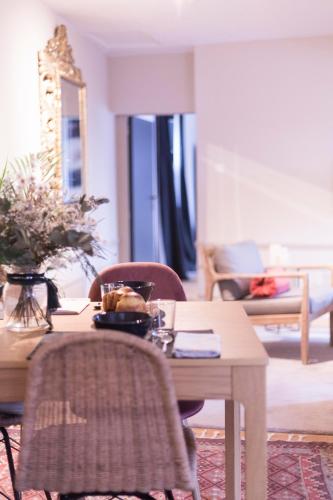 un salon avec une table et des chaises en bois dans l'établissement Sweet Home Rennes Centre Historique 65 m2, à Rennes