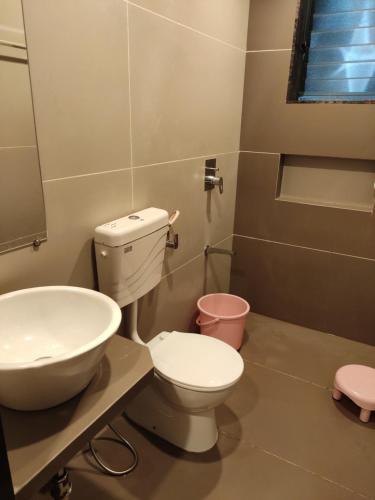 a bathroom with a toilet and a sink at Amit Niwas in Mahabaleshwar