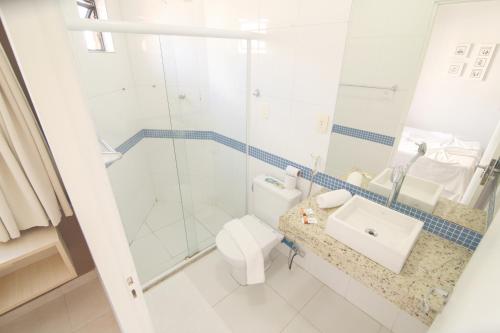 a bathroom with a shower and a toilet and a sink at Pousada Capital das Águas in Maceió
