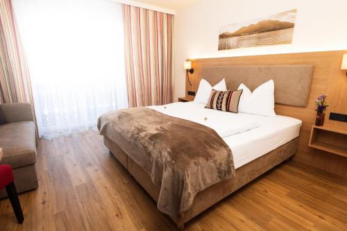 a hotel room with a bed and a couch at Frühstückspension Huber in Fuschl am See