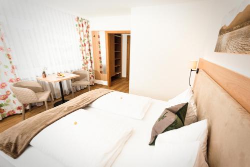 a small room with a bed and a table at Frühstückspension Huber in Fuschl am See