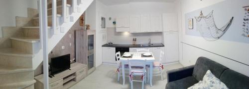 cocina y sala de estar con mesa y sofá. en Cala Sardinia Apartment, en Viddalba