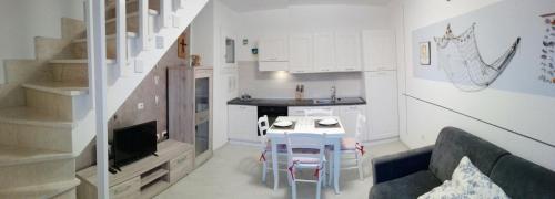 a kitchen and a living room with a table and a couch at Cala Sardinia Apartment in Viddalba