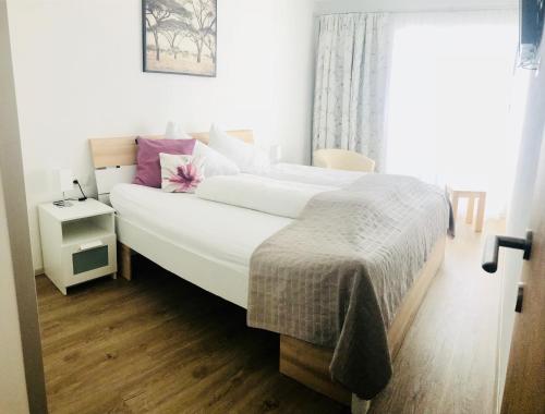 ein Schlafzimmer mit einem großen Bett mit weißer Bettwäsche in der Unterkunft Haus Seeblick in See