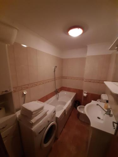 a bathroom with a tub and a toilet and a sink at Dražen Apartment in Orebić