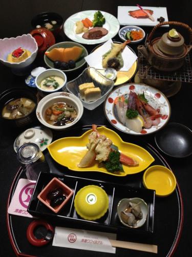 a table with many plates of food on it at Akakura Wakui Hotel in Myoko