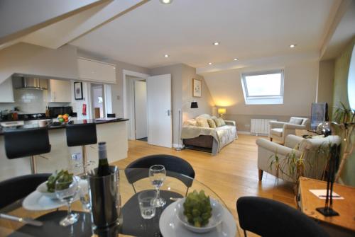 a living room with a dining table and a kitchen at Two Bedroom Apartments in Central Windsor with Parking in Windsor