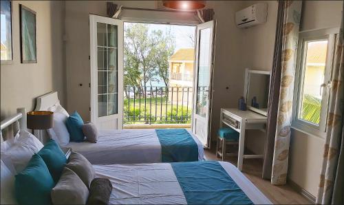 a bedroom with two beds and a desk and a balcony at Palmar Beach Villa in Palmar