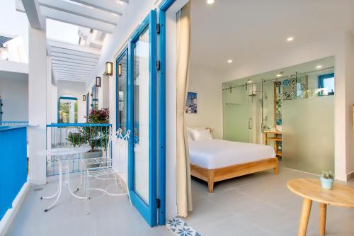 a bedroom with a bed and a table at Santorin HoiAn Villa in Hoi An