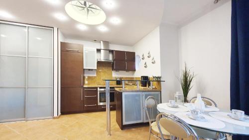 een keuken met een tafel en stoelen in een kamer bij Apartament Promenada in Świnoujście
