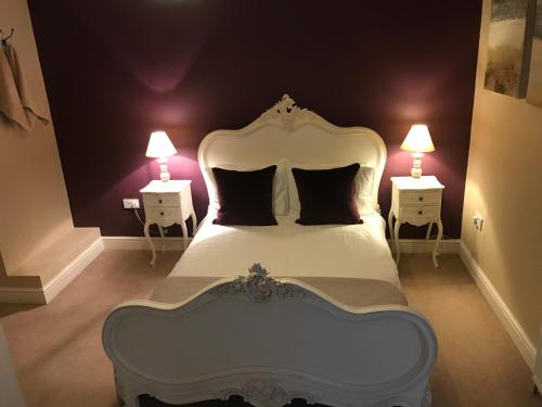 a bedroom with a white bed with two night stands at Cosy house set in historic town of Clitheroe in Clitheroe