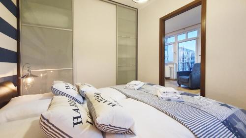 een slaapkamer met een bed en een grote spiegel bij Apartament Promenada in Świnoujście