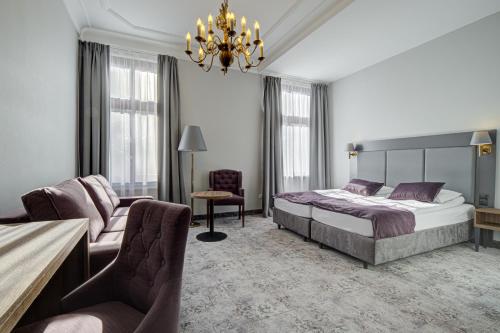 Un dormitorio con una cama, un sofá y una silla. en Pałac Cieszyno, en Złocieniec