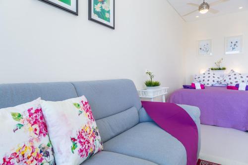 a living room with a blue couch with colorful pillows at Carmencita Studio B14 with pool & gym in Limassol