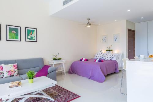 uma sala de estar com uma cama e um sofá em Carmencita Studio B14 with pool & gym em Limassol